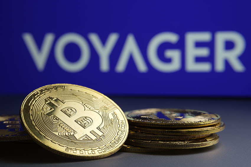 Some coins are stocked on a table that is kept before a blurred background that reads Voyager