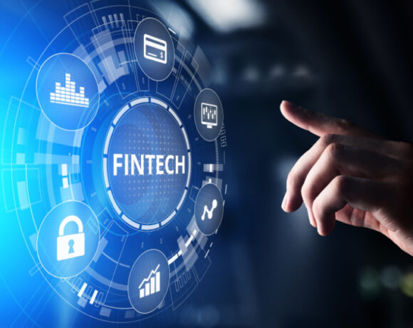 A hand is touching a virtual screen displaying Fintech Financial technology concept.