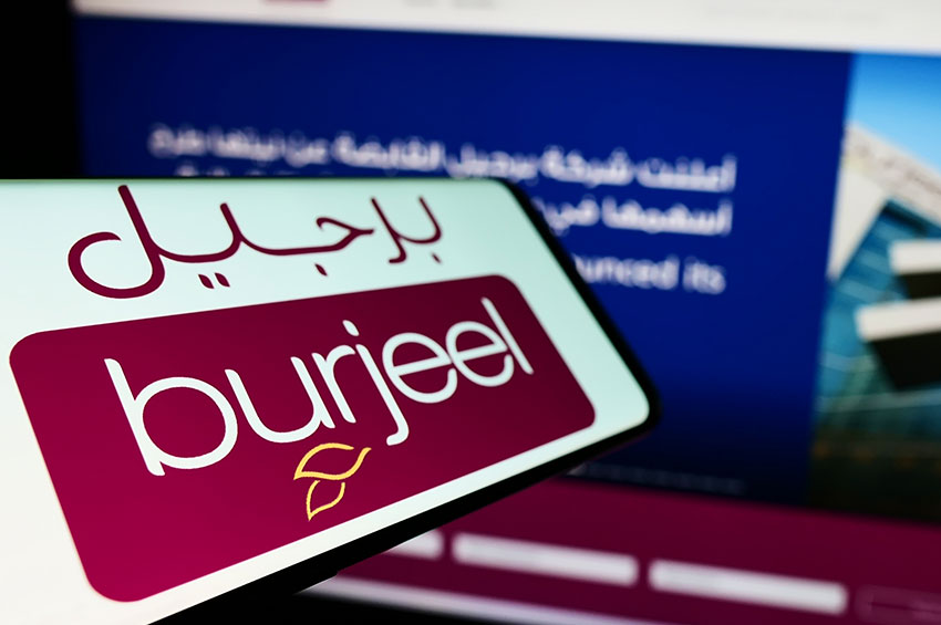 Closeup shot of a smartphone with burjeel logo kept in front of a burjeel website.