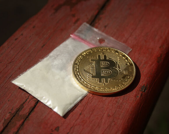 A coin is kept on a pack of cocaine drug