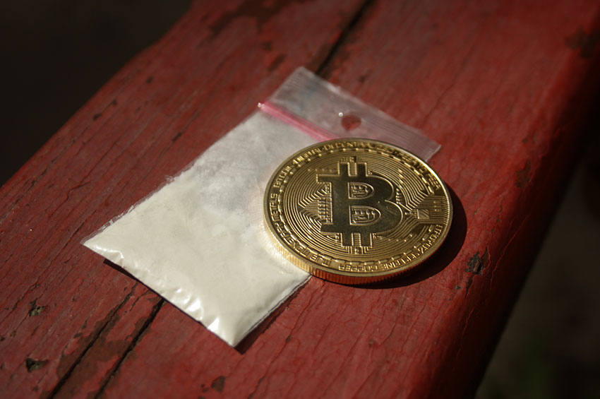 A coin is kept on a pack of cocaine drug