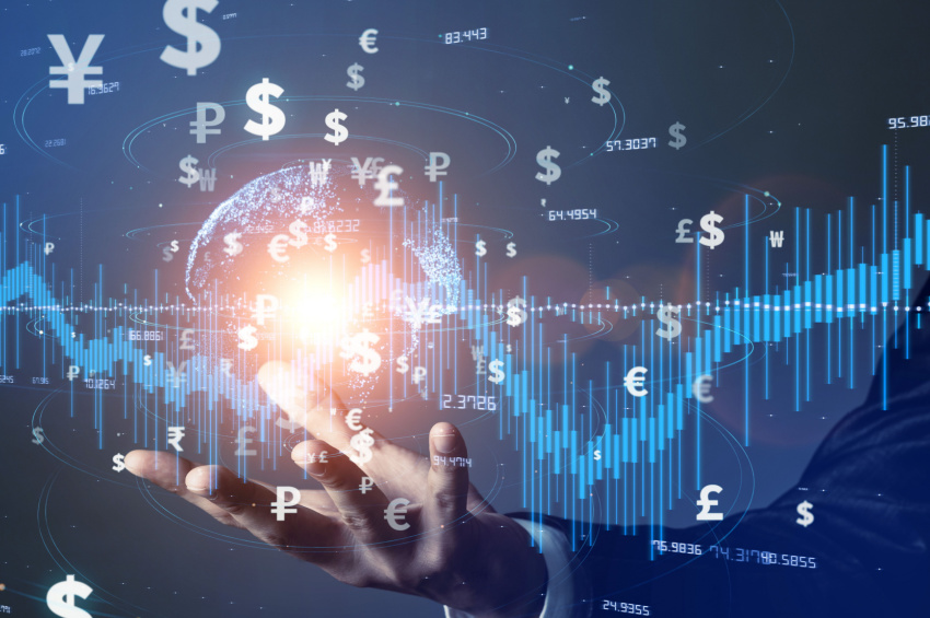 A double exposure image of a businessman holding a digital earth and stock analysis chart with global money symbols illustrates global Fintech investment.