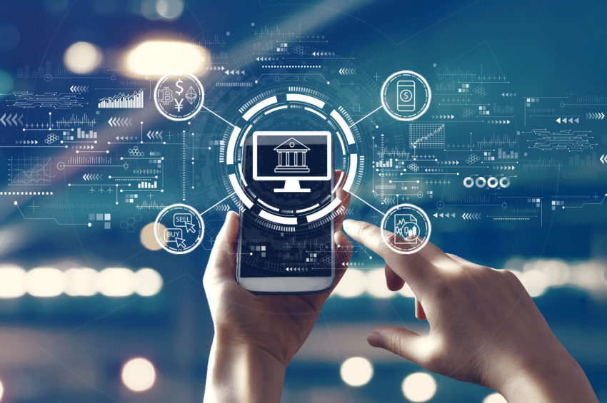 The image illustrates the Fintech theme with a person using a smartphone illustrates Stripe's launch of Enhanced Issuer Network to combat fraud.