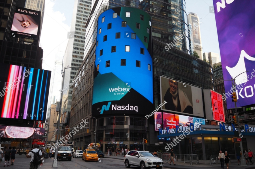NASDAQ, National Association of Securities Dealers Automated Quotations, and Cisco Webex corporate logo sign near Times Square illustrate Nasdaq's delisting notice to Ozon Holdings.
