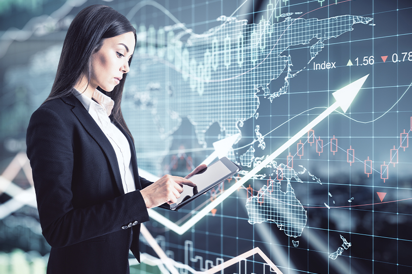 A concentrated businesswoman using a digital tablet on a virtual wall background with stock market changes illustrates the SoFi stock forecast.