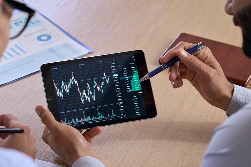 Square stock price prediction is illustrated by business investors discussing a trading chart using a digital tablet.